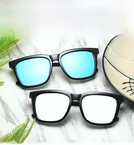 Polarized square sunglasses set with blue mirrored and clear lenses on marble surface