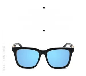 Detail of oversized black frame sunglasses with light blue lenses and gold metal accents