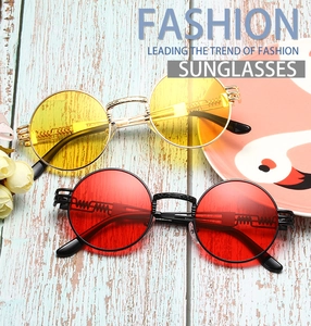 Detail of steampunk sunglasses with metal spring legs in gold-yellow and black-red lens