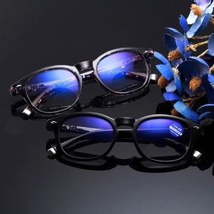 Chic anti-blue light bifocal reading glasses in black and tortoise frames on reflective base
