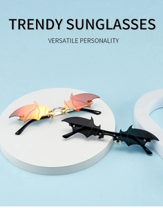 Detail of bat-shaped rimless sunglasses featuring red gradient and black lenses