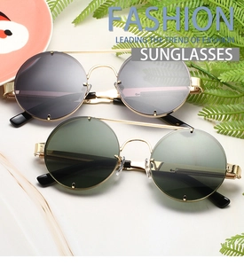 Flat lay of vintage round sunglasses with gold metal frames and dark tinted lenses
