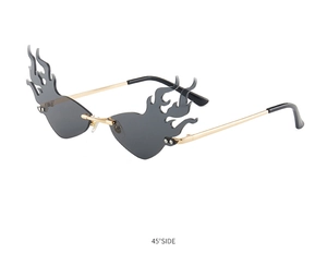 Detail shot of flame-shaped rimless sunglasses with gold metal frame from a 45-degree angle