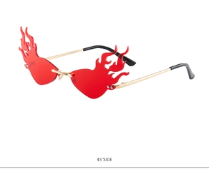 Detail of red flame-shaped rimless sunglasses with gold metal frame from 45 degree angle