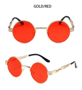 Detail of round steampunk sunglasses featuring gold metal frame and red tinted lenses