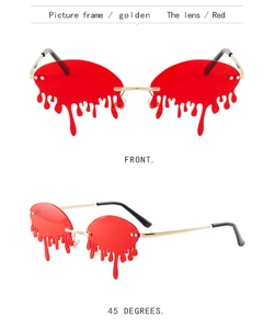 Detail of red teardrop shaped rimless sunglasses with elegant golden metal temples