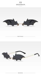 Detail view of gothic bat-shaped rimless sunglasses in gold frame with black lenses