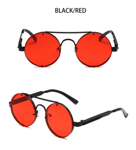 Detail of round punk sunglasses with black metal frames, red lenses and spring hinges