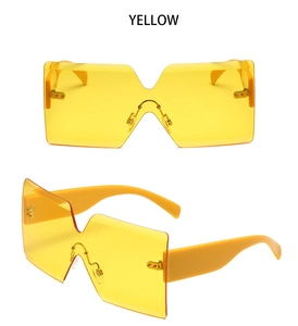 Detail view of yellow rimless oversized sunglasses with geometric one-piece lenses