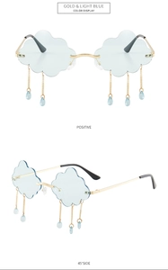 Macro detail of cloud-shaped sunglasses with golden metal frames and hanging blue tassels