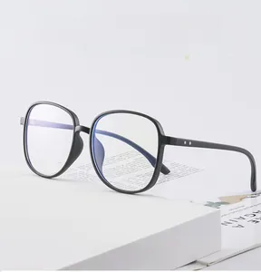 Dettaglio montatura occhiali nera TR90 anti-luce blu su supporto bianco con libri