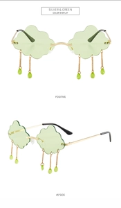 Macro view of cloud-shaped rimless sunglasses with green lenses and hanging droplets