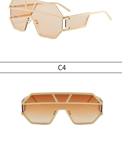 Detail view of oversized geometric sunglasses with orange lenses and hollow gold temples