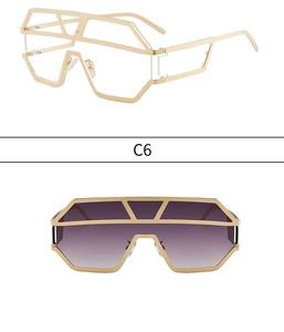 Detail of oversized geometric sunglasses with gold metal frame and purple gradient lenses