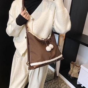 Détail du sac cabas en similicuir marron avec bordure en polaire blanche et nœuds