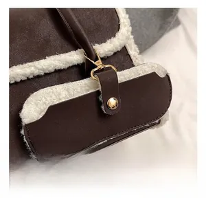 Detail of dark brown leather handbag featuring white faux fur trim and gold metal hardware