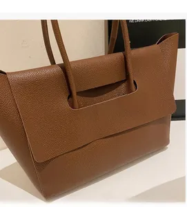 Détail du cabas en cuir marron foncé avec une conception de poignée intégrée unique