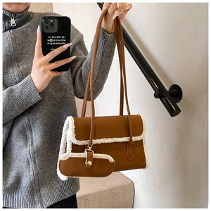 Brown leather shoulder bag with white faux shearling trim and matching mini pouch accessory