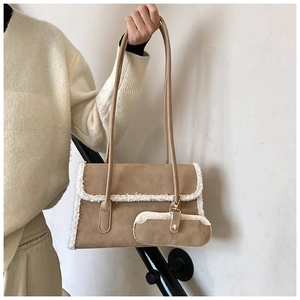 Close-up of khaki suede shoulder bag with white shearling trim and mini pouch detail
