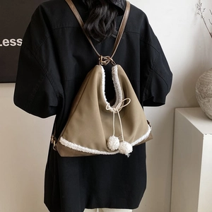 Gros plan du sac à dos triangle kaki avec garniture en fausse fourrure et pompons doux