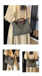 Detail of green plaid tote bag with brown leather flap and silver buckle closure