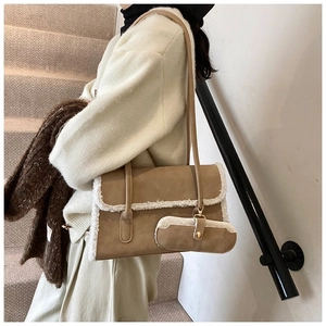 Detail of khaki suede shoulder bag featuring white faux fur trim and mini coin purse charm