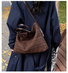 Brown checkered tote bag worn with a navy trench coat in a cozy autumn park setting