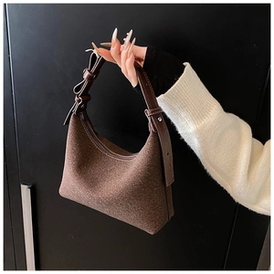 Dettaglio della borsa hobo marrone con superficie in tessuto e tracolla in pelle