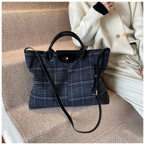 Detail of grey diamond lattice tote with leather flap and adjustable shoulder strap