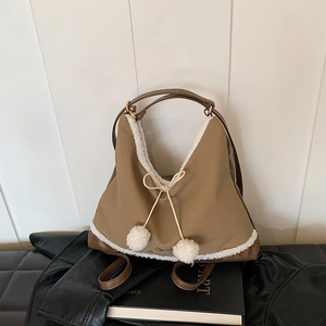 Détail du sac en nylon kaki avec bordure en simili mouton blanc et cordons à pompons doux