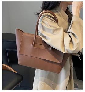 Gros plan sur le sac cabas en cuir grainé marron avec rabat et fines poignées