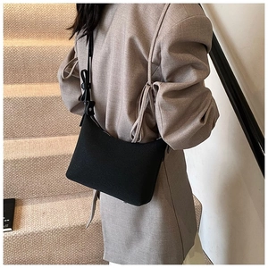 Borsa sottobraccio minimalista in ecopelle nera con fibbia tonda decorativa sulla tracolla