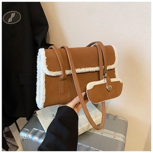 Detail of brown faux suede shoulder bag with plush white faux fur trim and mini coin purse