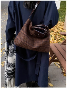 Detailed view of the brown check wool texture and leather handle of this tote bag