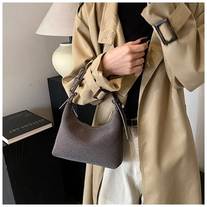 Dettaglio di una borsa a tracolla vintage caffè scuro opaco con nodo decorativo sul manico