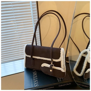 Detail of dark brown shearling shoulder bag with plush trim and matching small coin purse