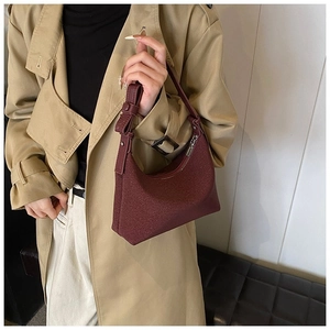 Dettaglio borsa hobo bordeaux con finitura testurizzata e tracolla con fibbia regolabile