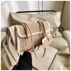 Detail view of beige matte underarm bag with thick white faux shearling trim and mini pouch