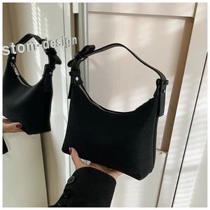 Dettaglio della borsa hobo in pelle scamosciata nera con manico annodato e zip argento