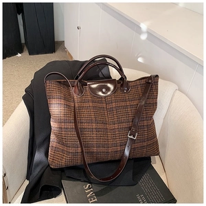 Detail of brown plaid tote with premium leather strap and silver buckle adjustment