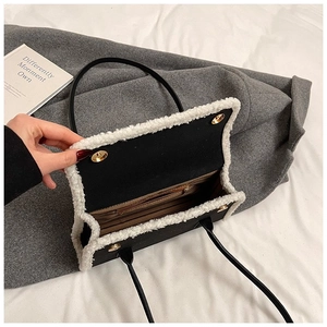 Detail of black underarm bag with white fleece trim and internal zipper pocket