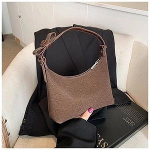 Dettaglio borsa hobo in pelle scamosciata marrone con fiocco 3D sulla tracolla