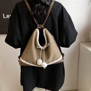 Sac à dos triangulaire kaki avec bordure en fausse fourrure blanche et pompons