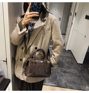 Mirror selfie showing the scale and style of dark brown Boston bowling bag worn crossbody