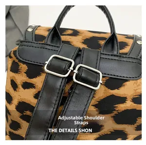 Detailed back view of leopard print backpack with adjustable black leather straps and studs