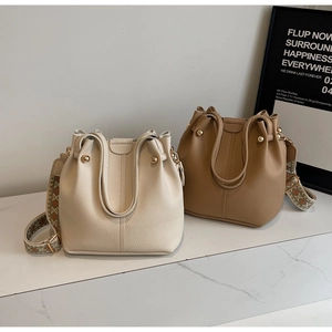 Close-up of bucket bags in beige and tan with bohemian style floral wide shoulder straps