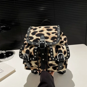 Leopard print canvas backpack with metallic rivets and black leather trim accents