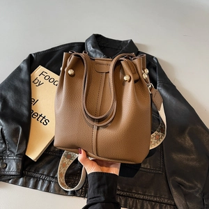 Brown litchi leather bucket bag featuring a vintage embroidered wide strap and gold hardware