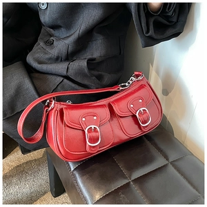 Detail of red glossy PU leather shoulder bag with vintage silver metal buckles