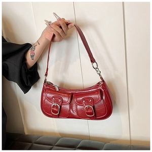 Macro detail of red oil wax leather shoulder bag with vintage silver buckles and texture